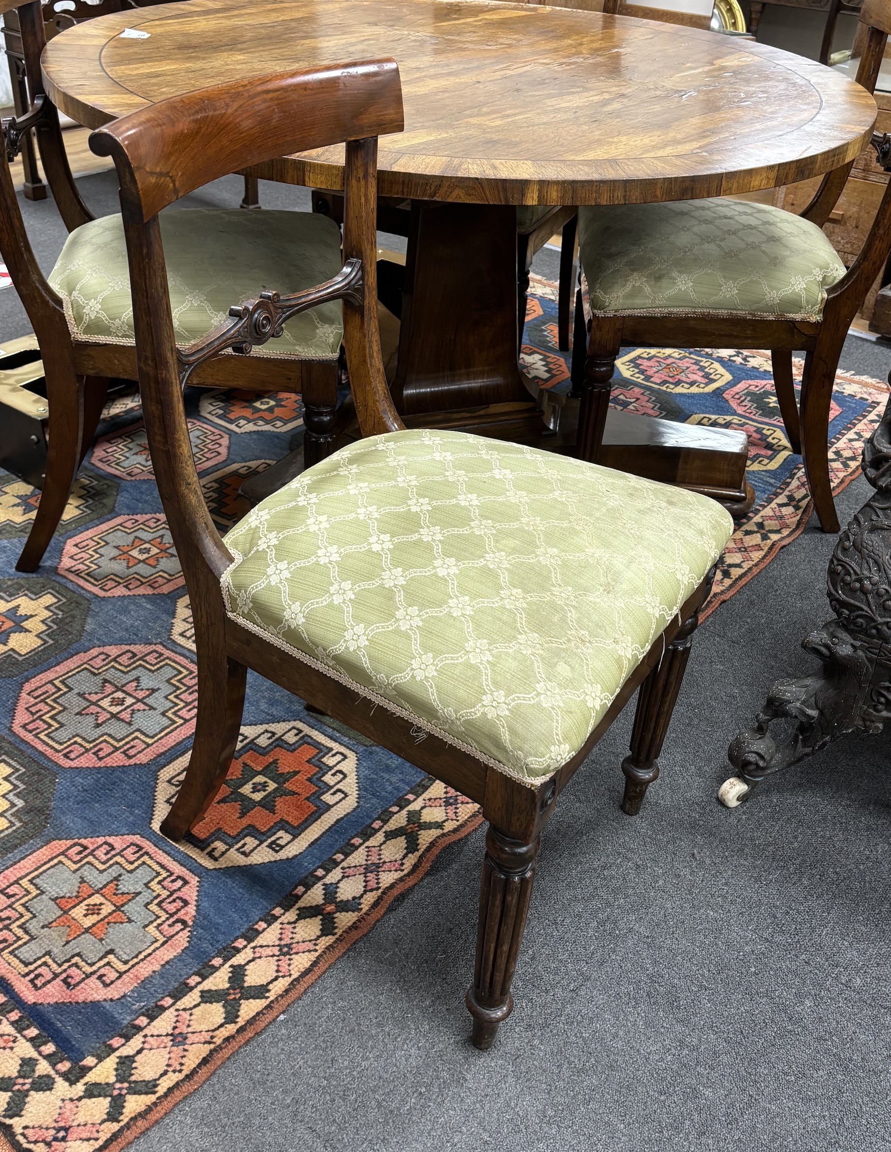 A Regency circular rosewood tilt top breakfast table, diameter 121cm, height 71cm together with four Regency rosewood dining chairs